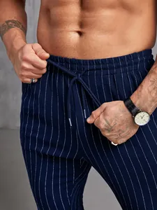 Détail du pantalon bleu marine à rayures avec cordon de serrage et texture du tissu