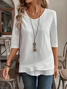 Detailed view of the elegant layered hem and soft fabric on this casual white top