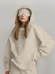 Vista detallada de una sudadera beige de gran tamaño para mujer con antifaz a juego.