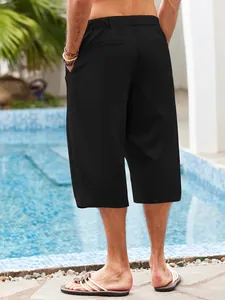 Macro back view of men's loose-fit black linen beach shorts by the pool