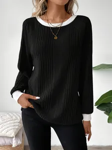 Vista detallada de camiseta negra de manga larga con cuello y puños en contraste blanco