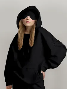 Detalle de sudadera negra oversize con capucha y un práctico bolsillo en la manga