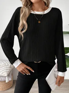 Detalle de camiseta casual negra de manga larga con puños y cuello en contraste de color blanco