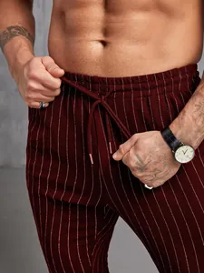 Gros plan sur un pantalon rayé bordeaux avec taille élastique et cordon de serrage