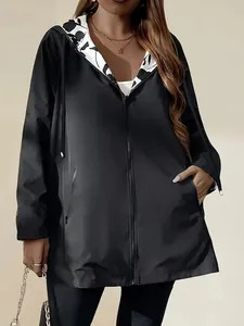 Close-up of lightweight black windbreaker jacket with patterned hood lining and zipper.