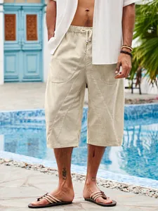 Detail view of men's beige cotton linen beach shorts with pockets and drawstring.