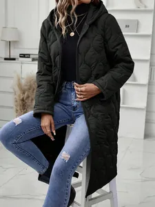 Detail of a women's black long hooded quilted coat in a stylish urban setting