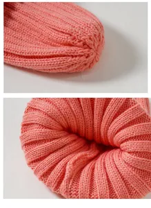 Primo piano di un berretto in maglia rosa con texture a coste morbide e cuciture di qualità.