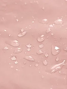 High-quality macro detail showing the pink waterproof jacket fabric with water droplets