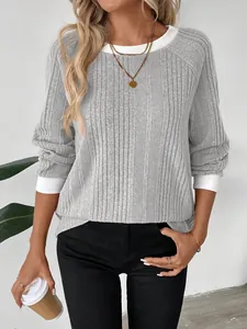 Top gris de canalé con manga larga, ribetes blancos en contraste y collar dorado
