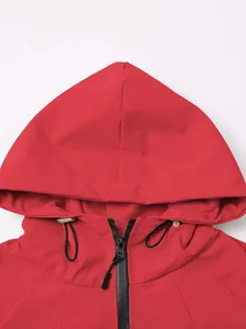 Detail showing the adjustable hood and black zipper of the red lightweight outdoor jacket