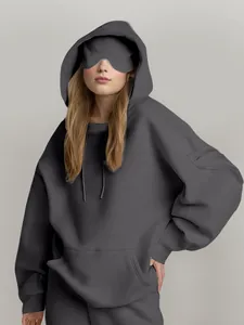 Detalle de sudadera gris oversize con máscara para ojos y bolsillo en la manga