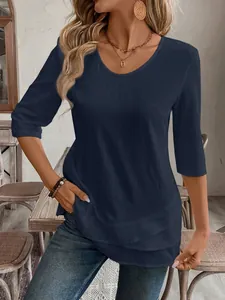 Close-up detail of a navy blue casual top featuring 3/4 sleeves and a layered hem design