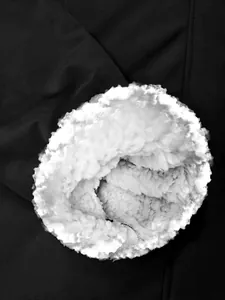 Close-up detail of the warm white fleece lining inside a black waterproof storm jacket