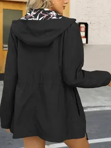 Back view of a women's black waterproof windbreaker with hood and slim waist design