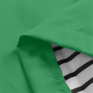 Dettaglio ravvicinato del tessuto verde della giacca impermeabile con fodera a righe bianche e nere
