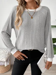 Detalle de camiseta gris de manga larga acanalada con puños y cuello blancos en contraste