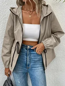 Detailed shot of a stylish khaki outdoor hooded windbreaker jacket worn with blue jeans