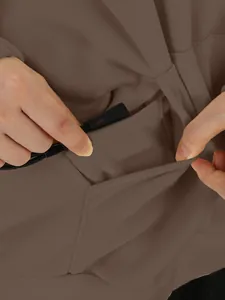 Detailed macro view showing the front pocket construction of a brown solid color hoodie
