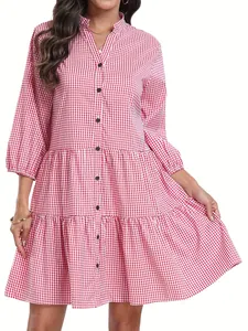 Détail d'une robe chemise à carreaux vichy rouge et blanc avec col officier et volants.