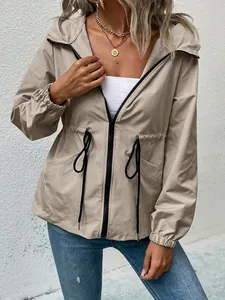 Detail of a khaki waterproof outdoor windbreaker jacket with waist drawstrings.
