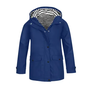 Dettaglio di una giacca blu con cappuccio per bambina con fodera a righe e tasche a bottoni.