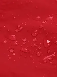 Close-up detail of waterproof red fabric showing water droplets on outdoor jacket