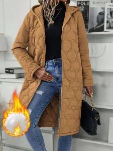 Detailed view of long quilted hooded jacket with diamond pattern on female model