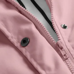 Close-up detail showing the durable zipper and snap button on a pink hiking jacket