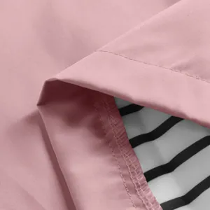 Close-up detail showing the texture of pink waterproof outdoor jacket with striped lining