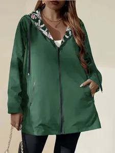 Detail of women's lightweight green windbreaker jacket with floral hood lining.