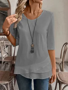 Close-up of casual gray round neck top featuring unique layered hem and 3/4 sleeves.