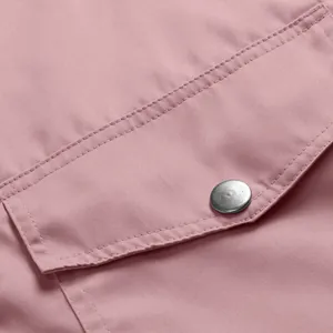Detailed macro shot of the pink waterproof outdoor jacket pocket and silver button