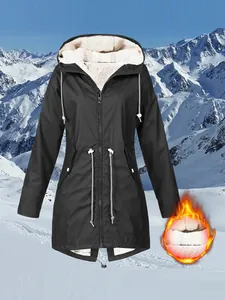 Close-up view of black fleece-lined outdoor jacket against a snowy mountain backdrop