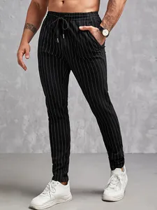 Détail de ce pantalon noir à fines rayures pour hommes, coupe ajustée avec cordon de serrage.