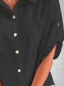 Detailaufnahme eines schwarzen Baumwoll-Leinenhemds mit Knöpfen und Tasche Textur