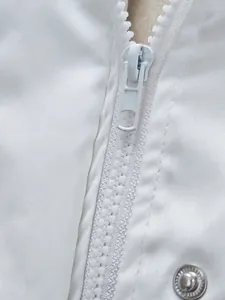 Vue détaillée de la fermeture éclair blanche et du tissu imperméable de cette veste
