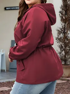 Side view detail of a burgundy hooded waterproof jacket with adjustable drawstring waist