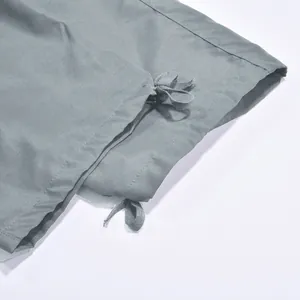 Primer plano del dobladillo con cordón ajustable en los pantalones cargo casuales grises de hombre.