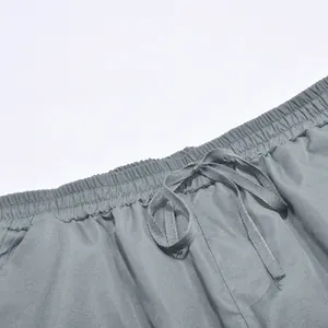 Detalle de pantalones cargo grises para hombre con cintura elástica y cordón ajustable.