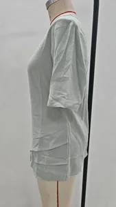 Detail view of light grey short-sleeved casual top with layered tiered hem on mannequin