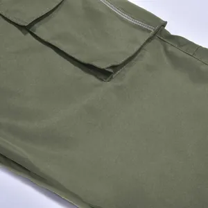 Detalle de pantalones cargo verde oliva con cremallera y bolsillo de solapa