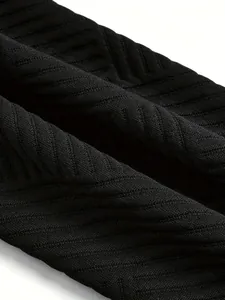 Dettaglio macro del tessuto a maglia a coste diagonali nere sulla manica di una giacca da donna