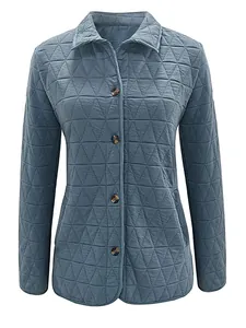 Macro view of blue quilted jacket featuring triangle pattern and brown faux tortoise buttons.