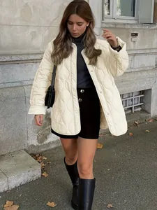 Eleganter cremefarbener Steppmantel mit Rundhals in einem modischen Streetstyle-Modefoto