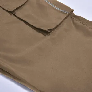 Detalle de primer plano de pantalones cargo marrones para hombre con bolsillo de solapa y cremallera