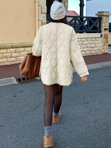 Rückansicht einer Frau in einer cremefarbenen minimalistischen oversized Steppjacke