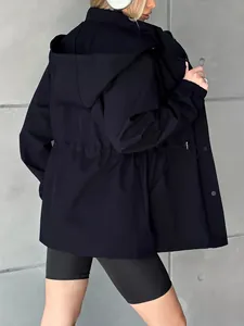Vue arrière d'une veste coupe-vent imperméable noire pour femme avec une capuche.