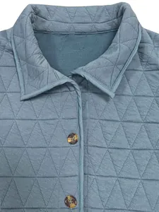 Close-up detail of blue quilted jacket featuring triangle stitching and buttons