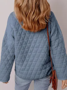 Detailed back view of a blue quilted cotton jacket featuring a triangular stitching pattern